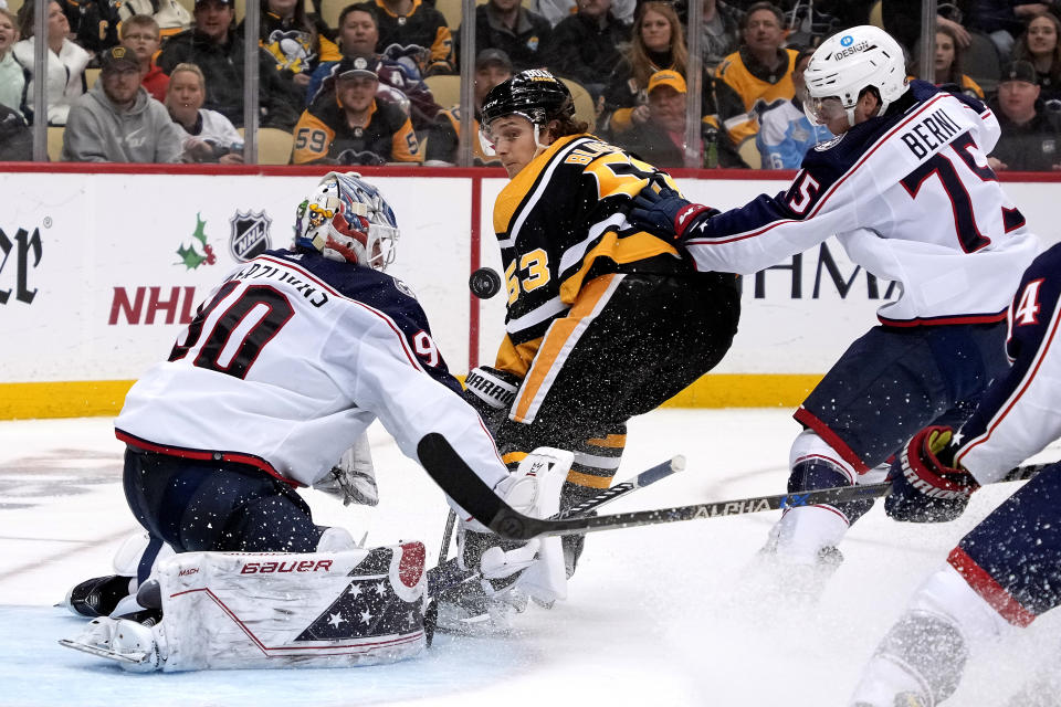 Columbus Blue Jackets goaltender Elvis Merzlikins stops a breakaway shot by Pittsburgh Penguins' Teddy Blueger with Tim Berni defending during the second period of an NHL hockey game in Pittsburgh, Tuesday, Dec. 6, 2022. Blueger was awarded a penalty shot on the play, and missed. (AP Photo/Gene J. Puskar)