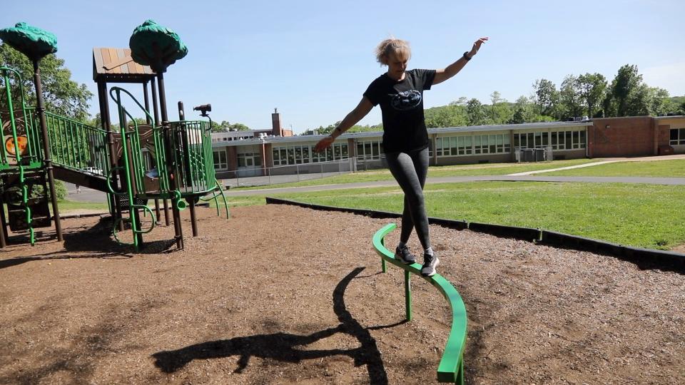 Breast-cancer survivor, Parsippany Hills track coach and triathlete Michelle Perry works on her balance at a playground near her Rockaway home. It is part of her workout for the Summit Challenge obstacle course fundraiser on June 5.