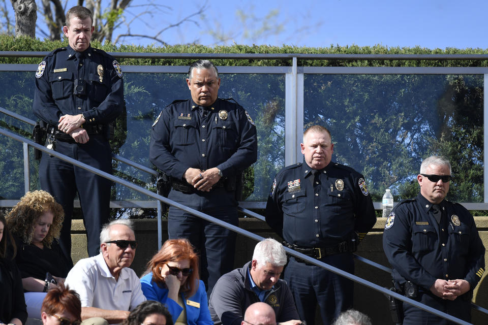 Officers with the Louisville Metro Police Department participate in a moment of silence during a vigil for the victims of Monday's shooting at the Old National Bank in Louisville, Ky., Wednesday, April 12, 2023. (AP Photo/Timothy D. Easley)