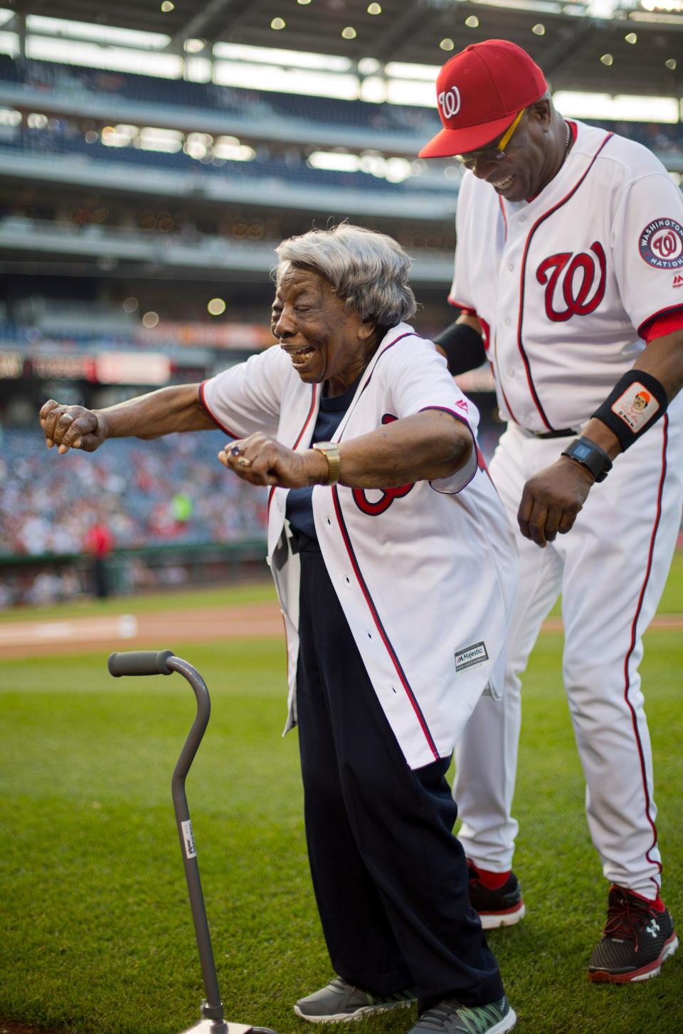 Virginia McLaurin, 107, reacts to receiving a team jersey from Washington Nationals manager Dusty Baker before the Nationals' baseball game against the St. Louis Cardinals at Nationals Park, Thursday, May 26, 2016, in Washington. McLaurin gained Internet fame for her impromptu dance with President Barack Obama in February during a Black History Month reception at the White House and said afterward that she could finally die happy.