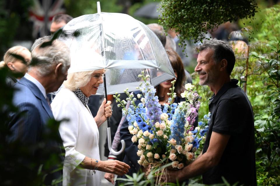 Charles and Camilla receive a gift during a visit to the central Paris Flower Market on day two of the state visit to France (PA)