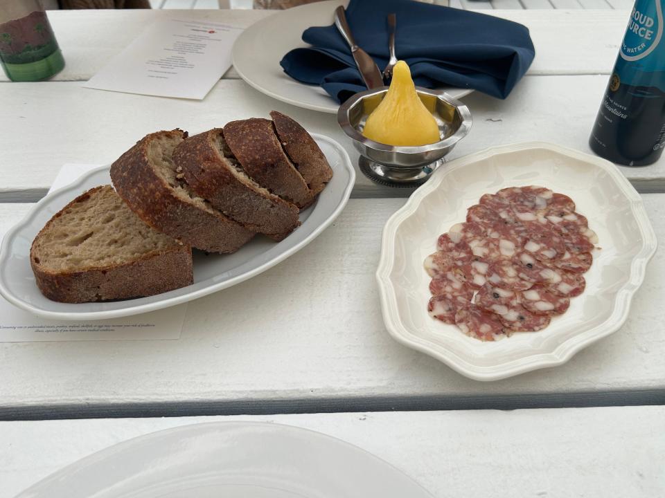 bread and charcuterie slices on white plates