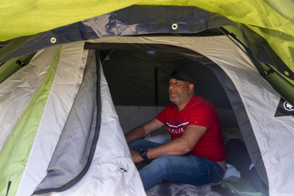 Jose Guerrero, of Puerto Cabello, Venezuela, sits in his tent at an encampment of asylum-seekers mostly from Venezuela, Congo and Angola next to an unused motel owned by the county, Wednesday, June 5, 2024, in Kent, Washington. (AP Photo/Lindsey Wasson)