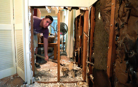 A volunteer from Texas A&M University helps to clean up flood damage in the house of an alumnus in southwestern Houston, Texas September 2, 2017. REUTERS/Rick Wilking