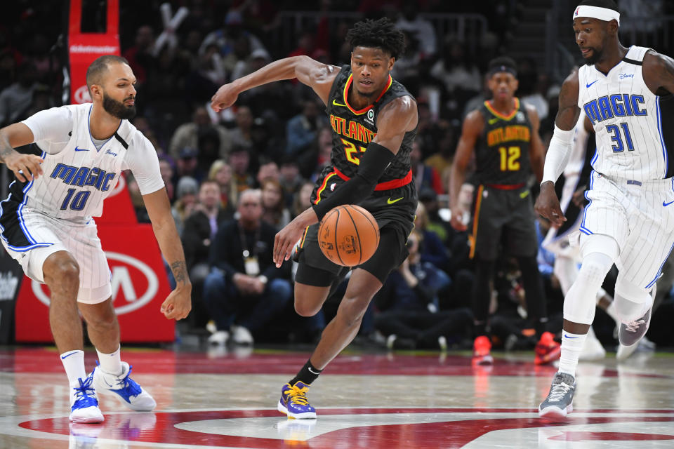 Atlanta Hawks guard Cam Reddish, Orlando Magic guard Evan Fournier (10) and guard Terrence Ross (31) chase a loose ball during the second half of an NBA basketball game Wednesday, Feb. 26, 2020, in Atlanta. Orlando won 130-120. (AP Photo/John Amis)