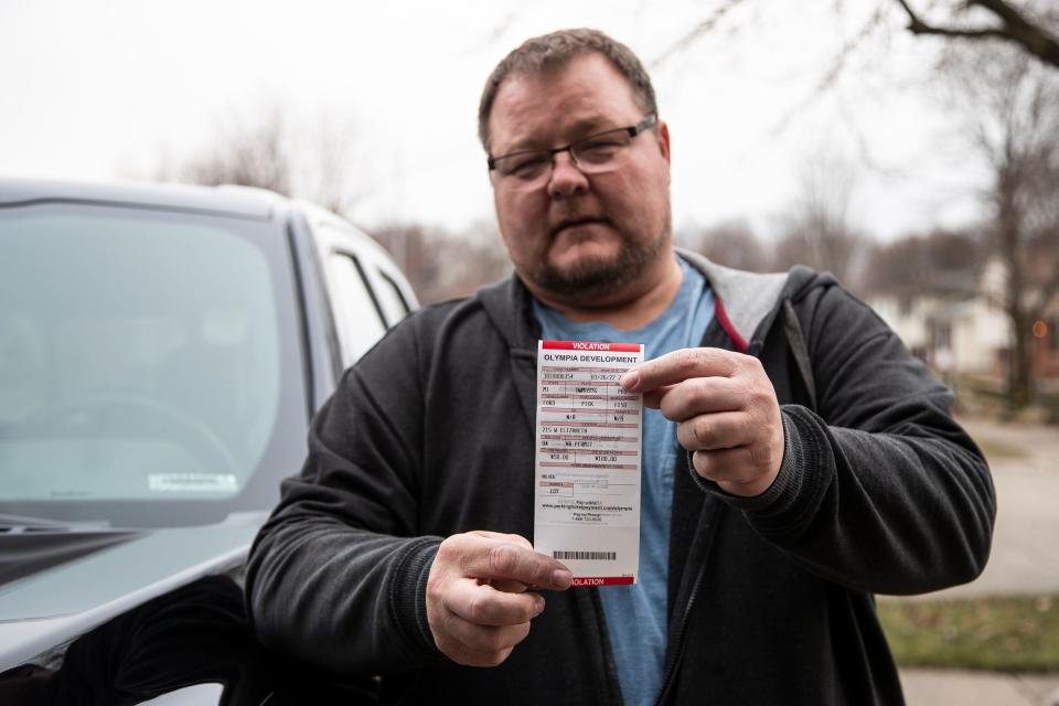 Matt Wilkinson of Westland shows the parking ticket he received from Olympia Development for parking his pickup at a lot on 215 West Elizabeth Street in downtown Detroit on March 26.