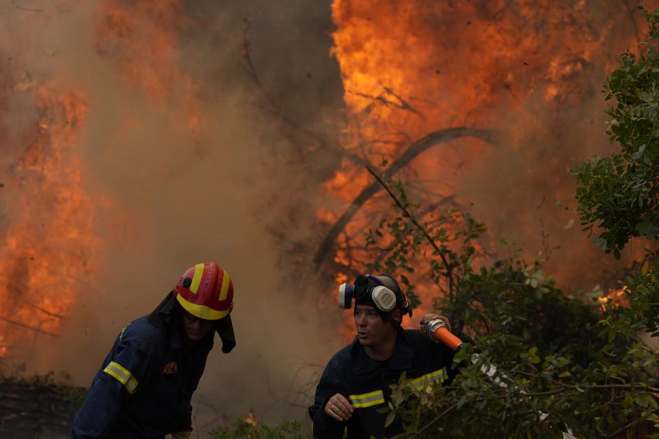 Firefighters operate at Ellinika village on Evia island, about 176 kilometers (110 miles) north of Athens, Greece, Monday, Aug. 9, 2021. Firefighters and residents battled a massive forest fire on Greece's second largest island for a seventh day Monday, fighting to save what they can from flames that have decimated vast tracts of pristine forest, destroyed homes and businesses and sent thousands fleeing. (AP Photo/Petros Karadjias)