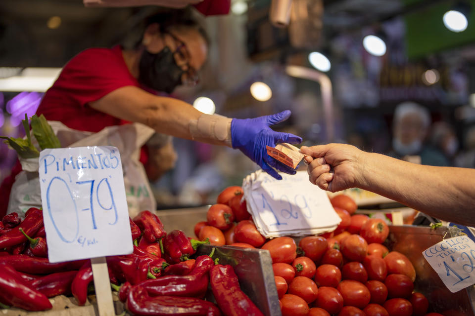 FILE - A customer pays for vegetables at the Maravillas market in Madrid, on May 12, 2022. Inflation for the European countries using the euro currency hit another record in August, fuelled by soaring energy prices mainly driven by Russia’s war in Ukraine. Annual inflation in the eurozone’s 19 countries rose to 9.1% in August, up from 8.9% recorded in July. That's according to the latest figures released Wednesday, Aug. 31, 2022 by the European Union statistics agency. (AP Photo/Manu Fernandez, File)