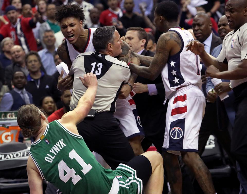 Wizards forward Kelly Oubre Jr., left, charges and knocks down Celtics center Kelly Olynyk on Thursday. (Getty Images)