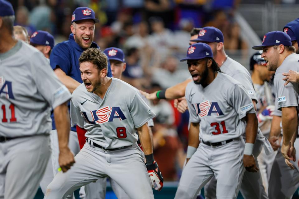 El campocorto del equipo de EE. UU., Trey Turner, celebra su grand slam con sus compañeros.