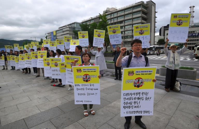 Protestors hold placards that read 'stop war exercise' during a rally denouncing the annual Ulchi Freedom Guardian (UFG) joint South Korea-US military exercise, near the US embassy in Seoul, on August 21, 2017