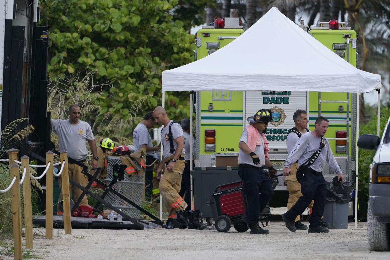 Firefighters unload a truck near the site where part of a 12-story beachfront condo building collapsed, Thursday, June 24, 2021, in Surfside, Fla.