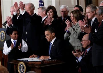 President Obama signs the health care bill into law.