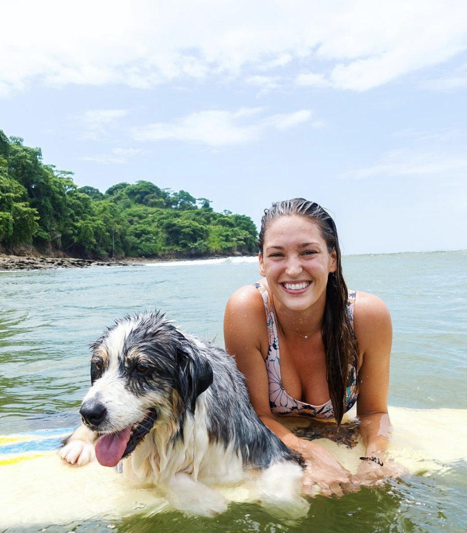 Lee Macmillan surfing with a dog.