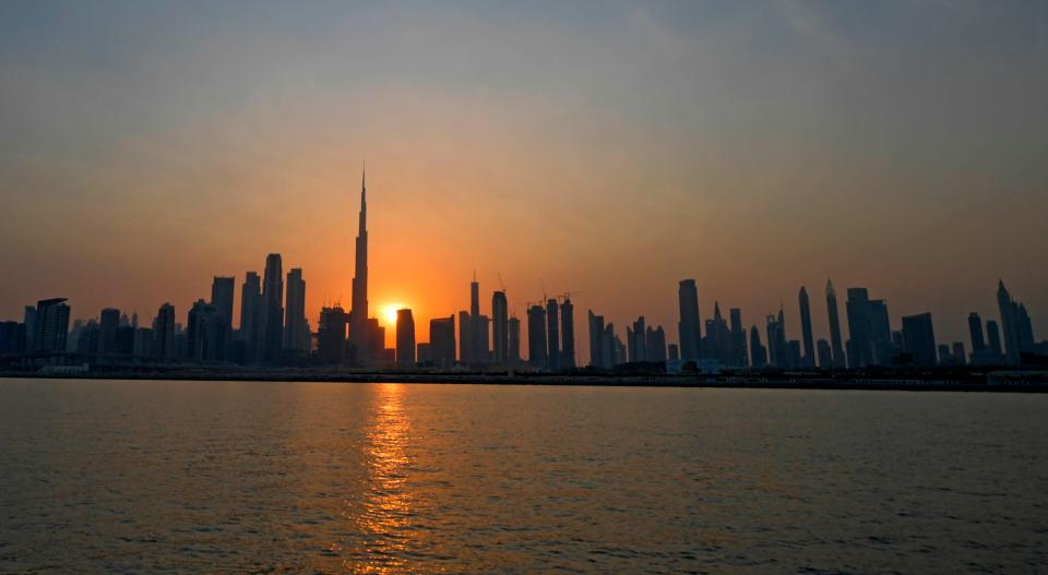 The sun sets behind Burj Khalifa and other high rise buildings, in the Emirati city of Dubai, on September 12, 2020.