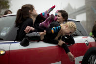 Participants laugh as they get themselves positioned to pose for mock-up photographs for the media after getting back in the car following a successful Guinness World Record attempt to fit 28 ladies into a Mini car backdropped by Tower Bridge in London, Thursday, Nov. 15, 2012. The attempt which broke the previous record of 27 people, was made to coincide with Guinness World Records Day, an annual event which organizers estimate will see in the region of 420,000 people attempting records around the globe. (AP Photo/Matt Dunham)