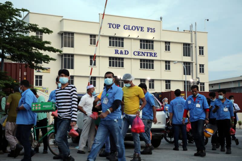 Workers leave a Top Glove factory after their shifts in Klang
