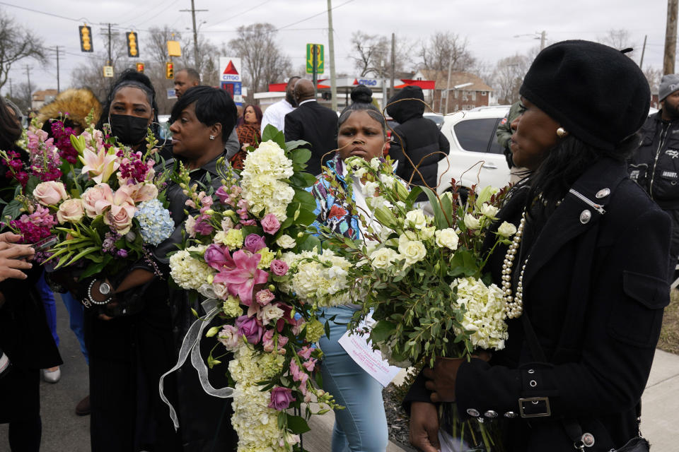 Mourners hold flowers after a funeral for Michigan State University shooting victim Arielle Anderson in Detroit, Tuesday, Feb. 21, 2023. Anderson, Alexandria Verner and Brian Fraser and were killed and several other students injured after a gunman opened fire on the campus of Michigan State University. (AP Photo/Paul Sancya)