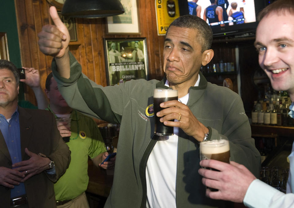 U.S. President Barack Obama (C) gives a thumbs-up as he celebrates St. Patrick's Day with a pint of Guinness during a stop at the Dubliner Irish pub in Washington, March 17, 2012.  REUTERS/Jonathan Ernst (UNITED STATES - Tags: POLITICS SOCIETY TPX IMAGES OF THE DAY)