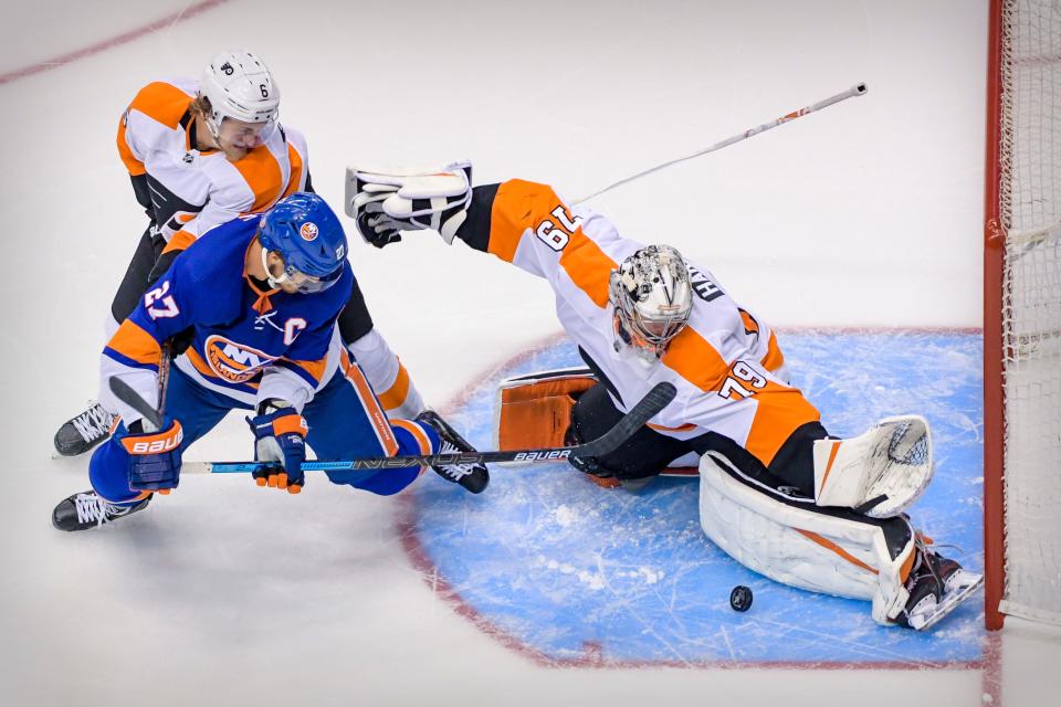 Philadelphia Flyers goaltender Carter Hart stops a shot by New York Islanders left wing Anders Lee during overtime of Game 6.