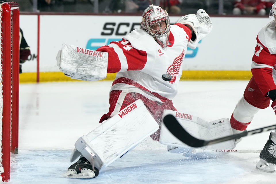 Detroit Red Wings goaltender Alex Lyon reaches back for the puck after losing his stick on a goal by Arizona Coyotes center Alex Kerfoot in the first period during an NHL hockey game, Friday, March 8, 2024, in Tempe, Ariz. (AP Photo/Rick Scuteri)