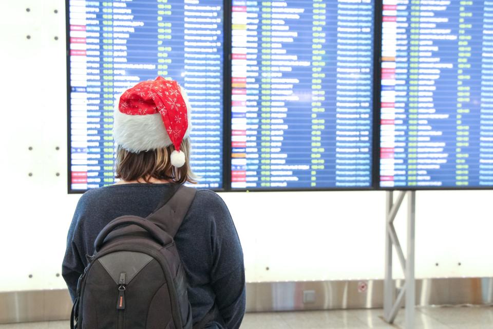 Eine Frau trägt im Flughafen eine Weihnachtsmütze. - Copyright: Andrey Rykov/Getty Images