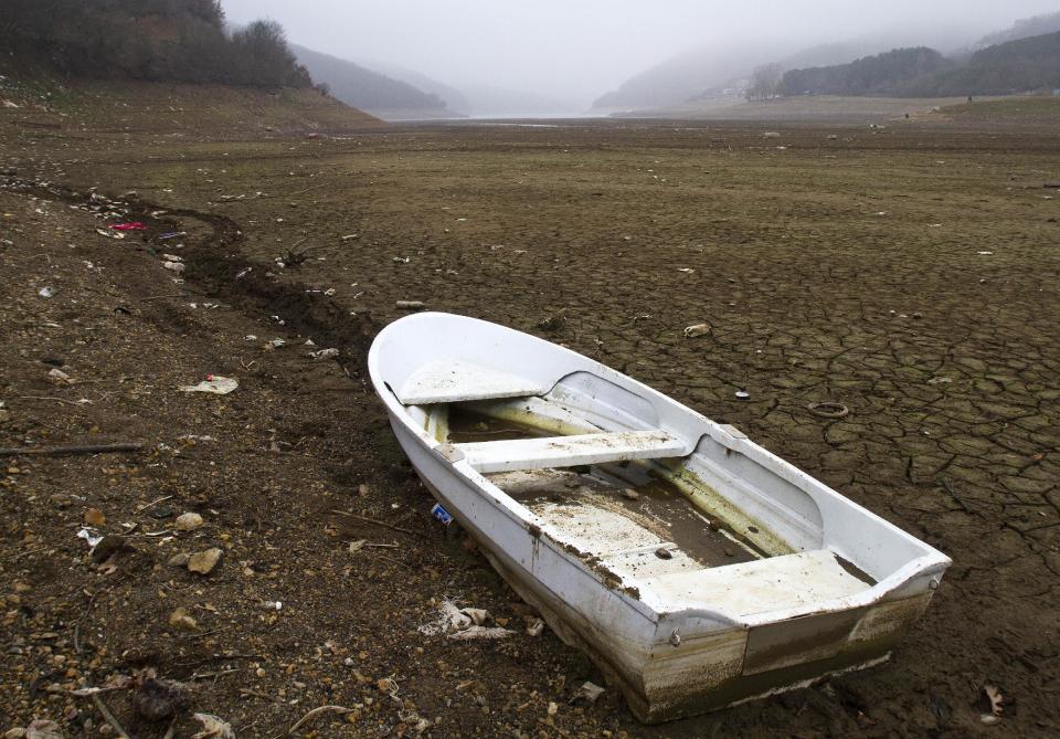 A boat lies stranded on the shores of the Batllava artificial lake in northern Kosovo on Wednesday, Jan. 8, 2014, after record low water levels threaten to leave hundred of thousands of people without a water supply. Authorities have reduced water supplies for hundreds of thousands of people after a unusually dry winter season. (AP Photo/Visar Kryeziu)