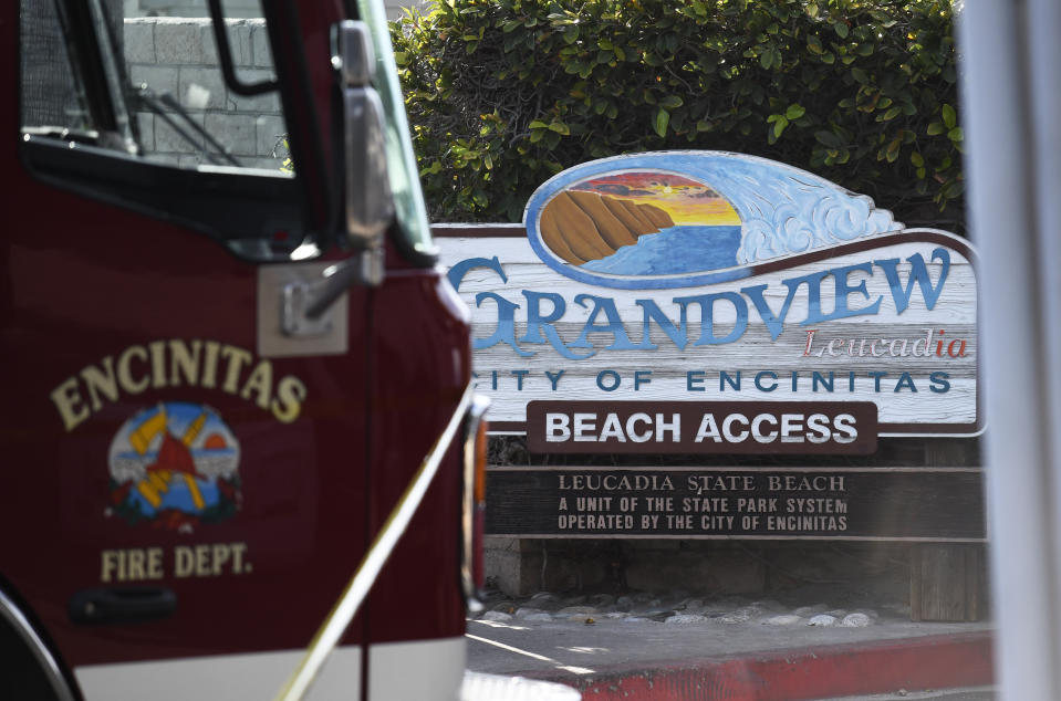 A fire truck sits above the site of a cliff collapse at a popular beach Friday, Aug. 2, 2019, in Encinitas, Calif. At least one person was reportedly killed, and multiple people were injured, when an oceanfront bluff collapsed Friday at Grandview Beach in the Leucadia area of Encinitas, authorities said. (AP Photo/Denis Poroy)