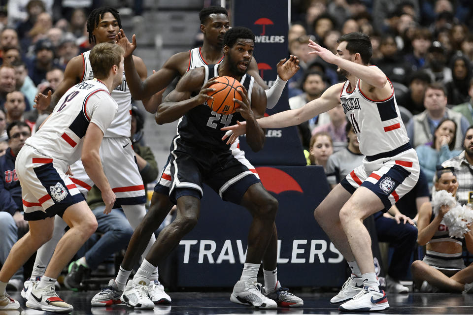 Georgetown's Supreme Cook, center, is pressured by, from left, UConn's Cam Spencer, Stephon Castle, Samson Johnson and Alex Karaban in the first half of an NCAA college basketball game, Sunday, Jan. 14, 2024, in Hartford, Conn. (AP Photo/Jessica Hill)