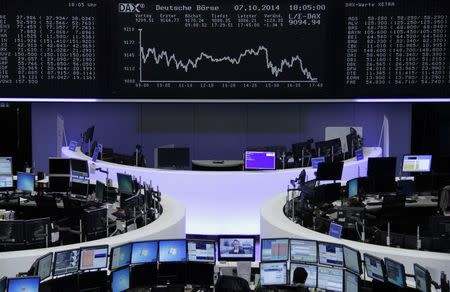 A trader is pictured at the desk in front of the DAX board at the Frankfurt stock exchange October 7, 2014. REUTERS/Remote/Stringer