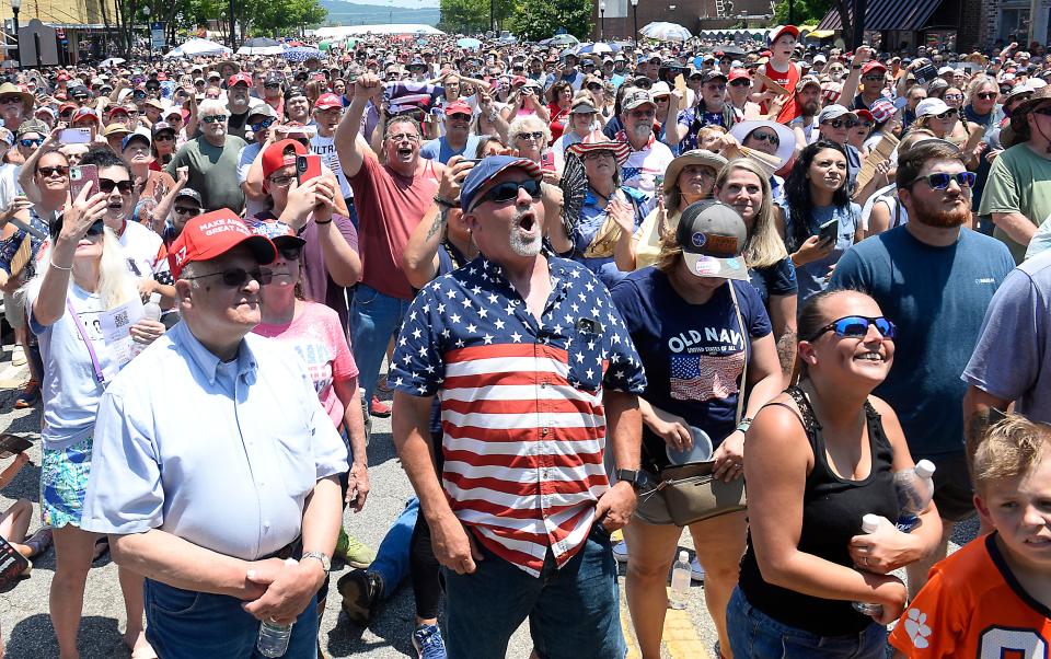 Guests react as former U.S. President Donald J. Trump takes the stage during the rally in downtown Pickens, S.C. Saturday, July 1, 2023. 