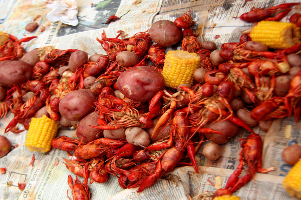 A crawfish boil on a table with newspaper