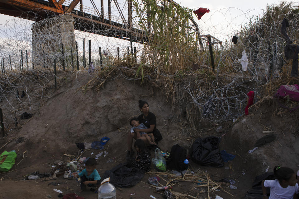 A woman who crossed into the U.S. from Piedras Negras, Mexico, rests on the banks of the Rio Grande in Eagle Pass, Texas, Friday, Sept. 22, 2023. (AP Photo/Jacky Muniello)