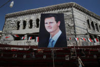 A man walks past a banner depicting Syrian president Bashar al-Assad in Douma, outside Damascus, Syria, September 17, 2018. REUTERS/Marko Djurica/Files