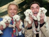 Las Vegas entertainers Siegfried & Roy, Siegfried Fischbacher, left, and Roy Uwe Ludwig Horn, right, hold four baby white lions at the Cincinnati Zoo, Thursday, April 26, 2001, in Cincinnati. The four cubs were born April 1 to two white lions loaned to the Cincinnati Zoo in 1998 by Siegfried & Roy. The cubs will be on display this summer at the zoo. (AP Photo/Al Behrman)