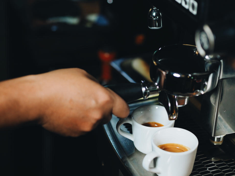 A worker operating a coffee machine.