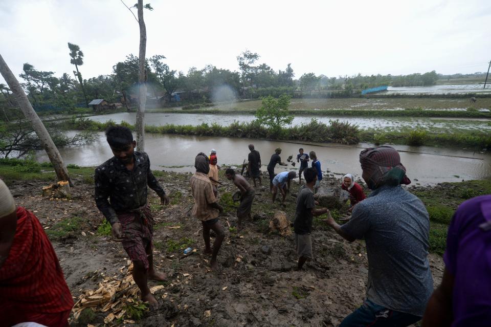 Villagers reinforce an embankment with sacks of soil ahead of the expected landfall of cyclone Amphan, in Dacope on May 20, 2020. (Photo by MUNIR UZ ZAMAN/AFP via Getty Images)