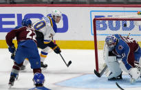 St. Louis Blues center Oskar Sundqvist, back, drives past Colorado Avalanche defenseman Conor Timmins, left, to score a goal against goaltender Philipp Grubauer in the third period of an NHL hockey game Wednesday, Jan. 13, 2021, in Denver. The Blues won 4-1. (AP Photo/David Zalubowski)