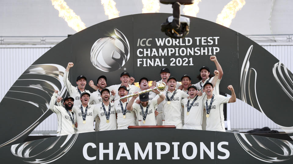 New Zealand players celebrate with the winners trophy after their win in the World Test Championship final cricket match against India, at the Rose Bowl in Southampton, England, Wednesday, June 23, 2021. New Zealand won the match by eight wickets. (AP Photo/Ian Walton)