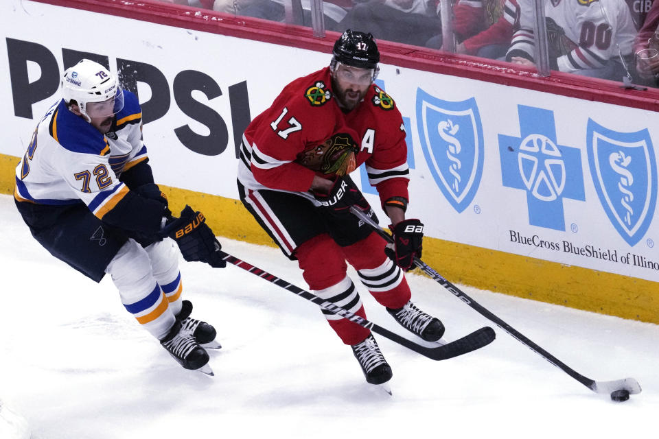 Chicago Blackhawks left wing Nick Foligno, right, looks to pass against St. Louis Blues defenseman Justin Faulk during the second period of an NHL hockey game in Chicago, Sunday, Nov. 26, 2023. (AP Photo/Nam Y. Huh)