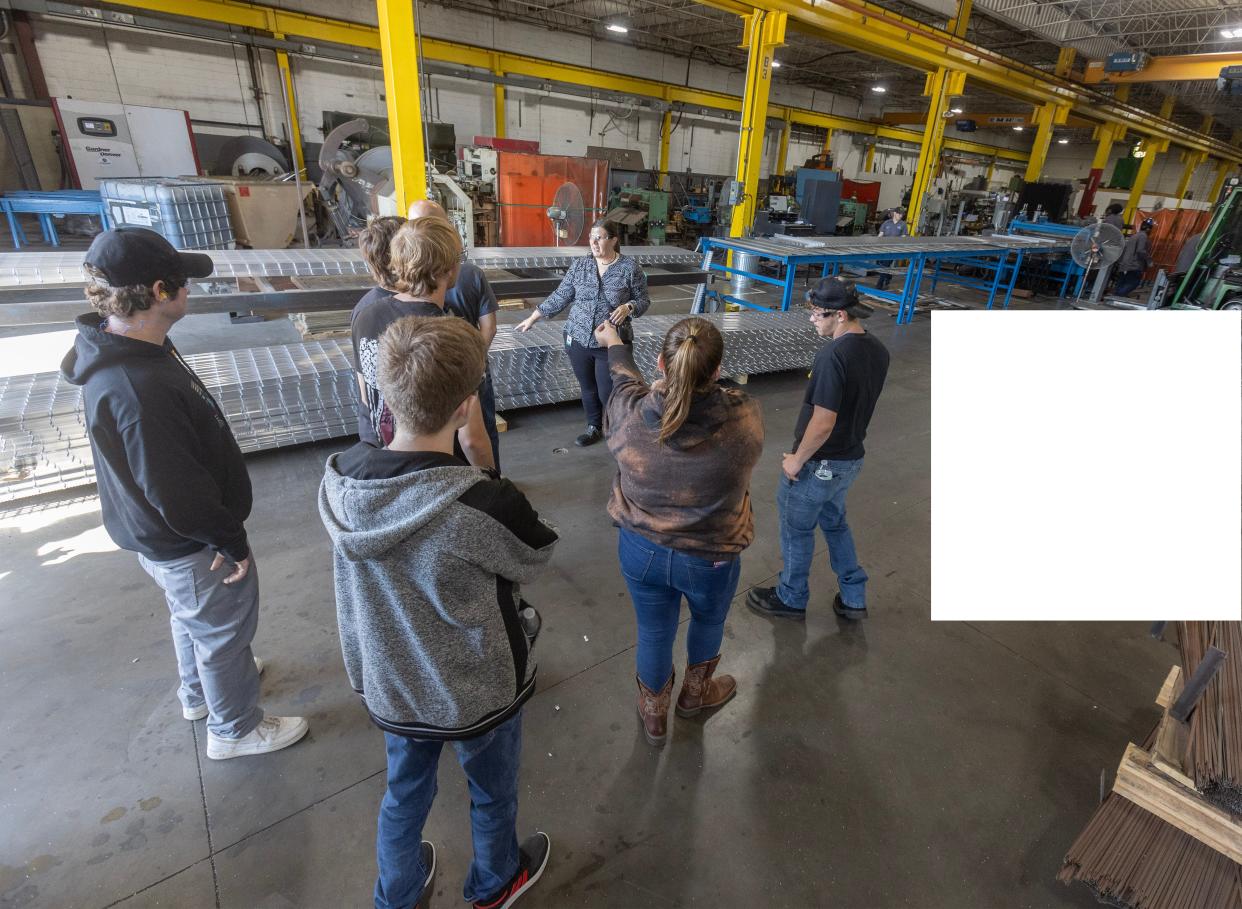 Jennifer VonWyl, center, a materials and logistics manager at Ohio Gratings in Perry Township, leads a tour of juniors and seniors from Sandy Valley High School through the factory for Manufacturing Day.