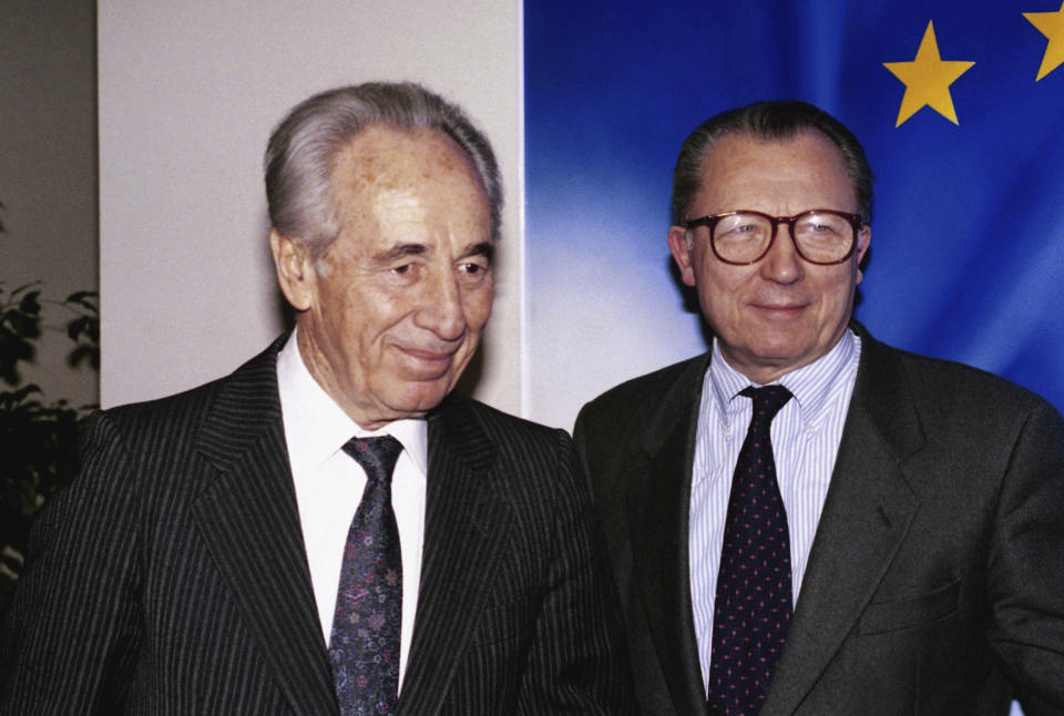 FILE - Israeli Foreign Minister Shimon Peres and Jacques Delors, president of the European Community Commission, are seen making their way to Delors office for talks in Brussels on Nov. 25, 1993. Delors, a Paris bank messenger’s son who became the visionary and builder of a more unified Europe in his momentous decade as chief executive of the European Union, has died in Paris, his daughter Martine Aubry said Wednesday Dec. 27, 2023. He was 98. (AP Photo/Carl Duyuck, File)