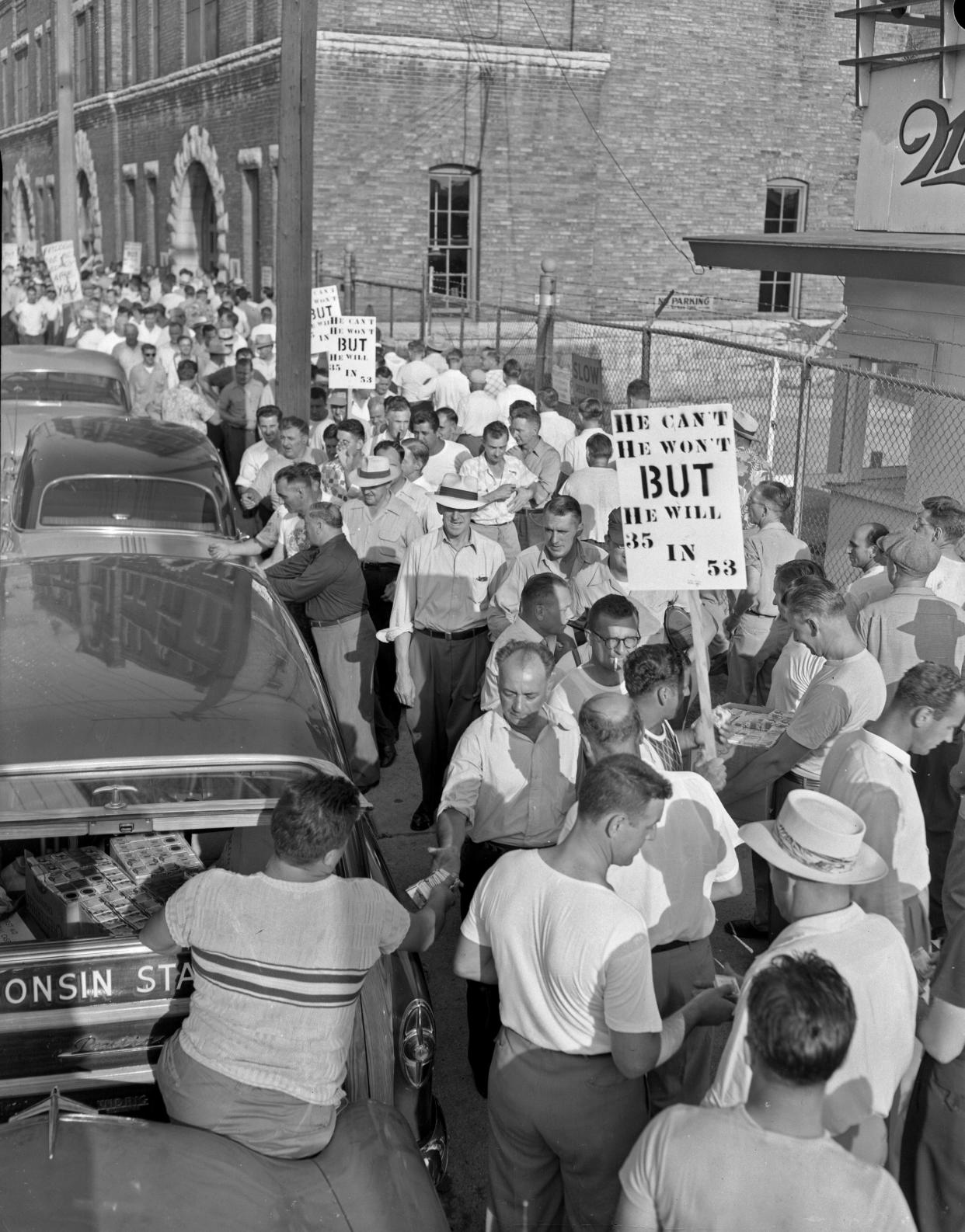 State CIO officials hand out cigarettes to strikers after a three-hour demonstration by about 1,500 workers at Miller Brewing on July 20, 1953. Signs blast brewery president Frederick C. Miller for opposing the union's demand for a 35-hour week.