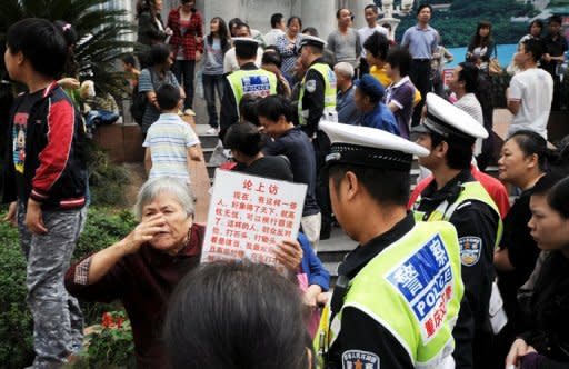 A Chinese policeman reads a petition held up by an elderly woman about alleged abuses by officials in Chongqing in 2010. More than 100 officials have been tried after police in 2009 exposed the impunity enjoyed by mafia bosses who terrorised Chongqing -- and the officials who protected them