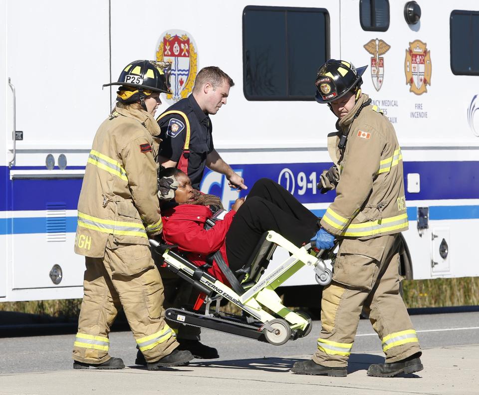 Emergency workers take a person away at the scene of an accident involving a bus and a train in Ottawa