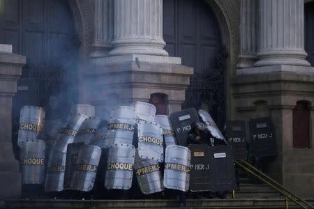 Policías antidisturbios se protegen de manifestantes durante una protesta contra las medidas de austeridad del presidente Michel Temer en Río de Janeiro, Brasil. 28 de abril de 2017. REUTERS/Ricardo Moraes