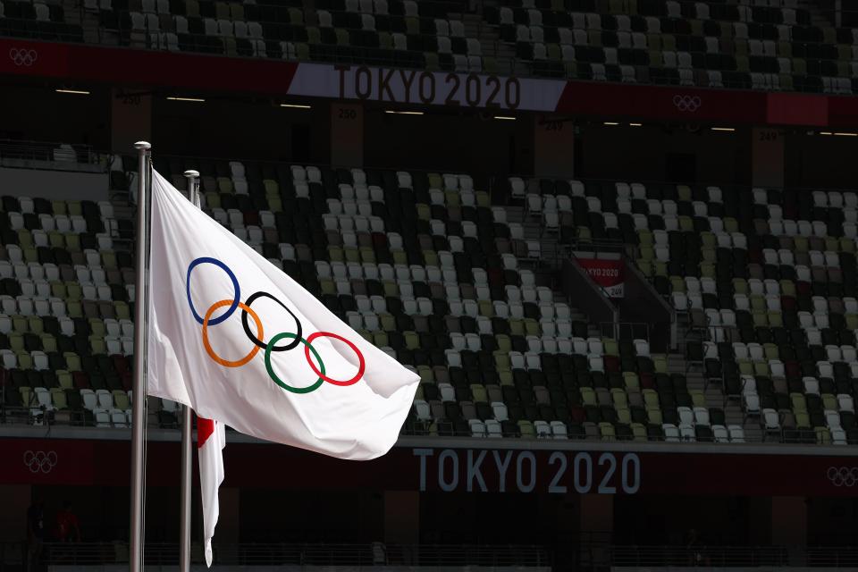 The Olympic and Japanese flags fly in front of rows of empty seats in the Olympic Stadium (Getty Images)