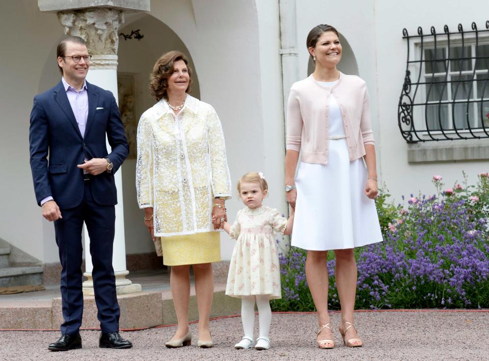 <p>Klare Linien und ein femininer Touch sind typisch für Victorias Stil. Den demonstrierte die Kronprinzessin 2014 bei einem Fototermin an ihrem 37. Geburtstag mit Ehemann Daniel, Mutter Silvia und Töchterchen Estelle (v.l.n.r.). (Bild: AP Photo) </p>