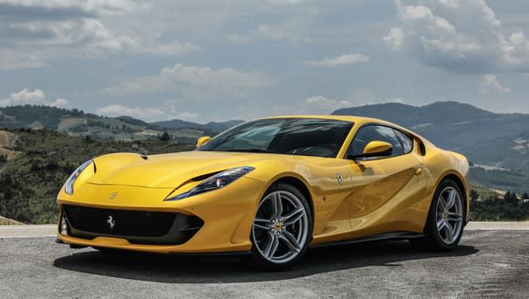 A yellow Ferrari 812 Superfast, a swoopy front-engined two-seat sports car.