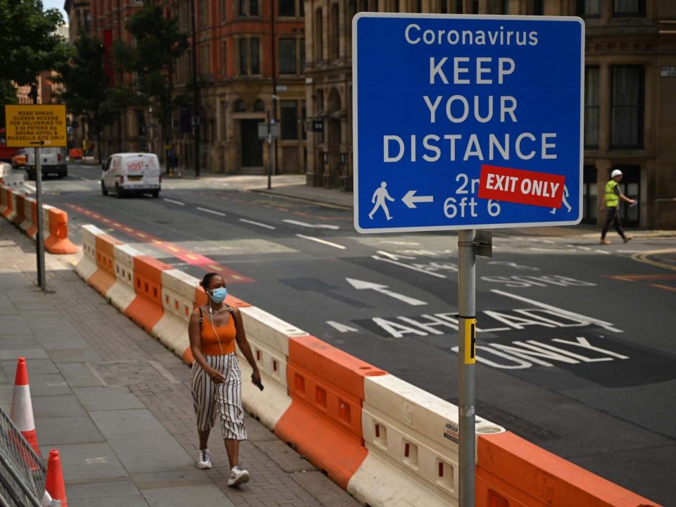 A woman wears a facemask as she walks in the centre of Manchester: AFP via Getty Images